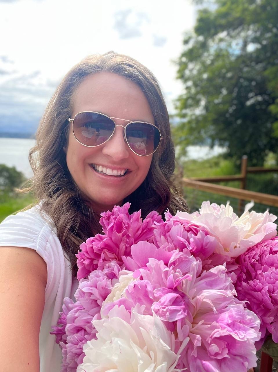 Stephanie smiling with a bouquet of pink and white flowers